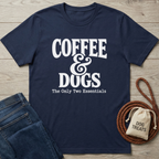 Navy blue cotton t-shirt with "Coffee & Dogs The Only Two Essentials" in white text, next to jeans and dog treats.