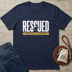 Navy blue "Rescued" t-shirt with dog silhouette, "Adopted & Adored" text, jeans, and dog treats.