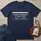 Navy blue Gildan Softstyle® t-shirt with "STATUS: DISTRACTED BY DOGS AGAIN" text in a white pop-up window.