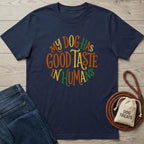 Navy blue cotton t-shirt with "My Dog Has Good Taste In Humans" in colorful, circular text.