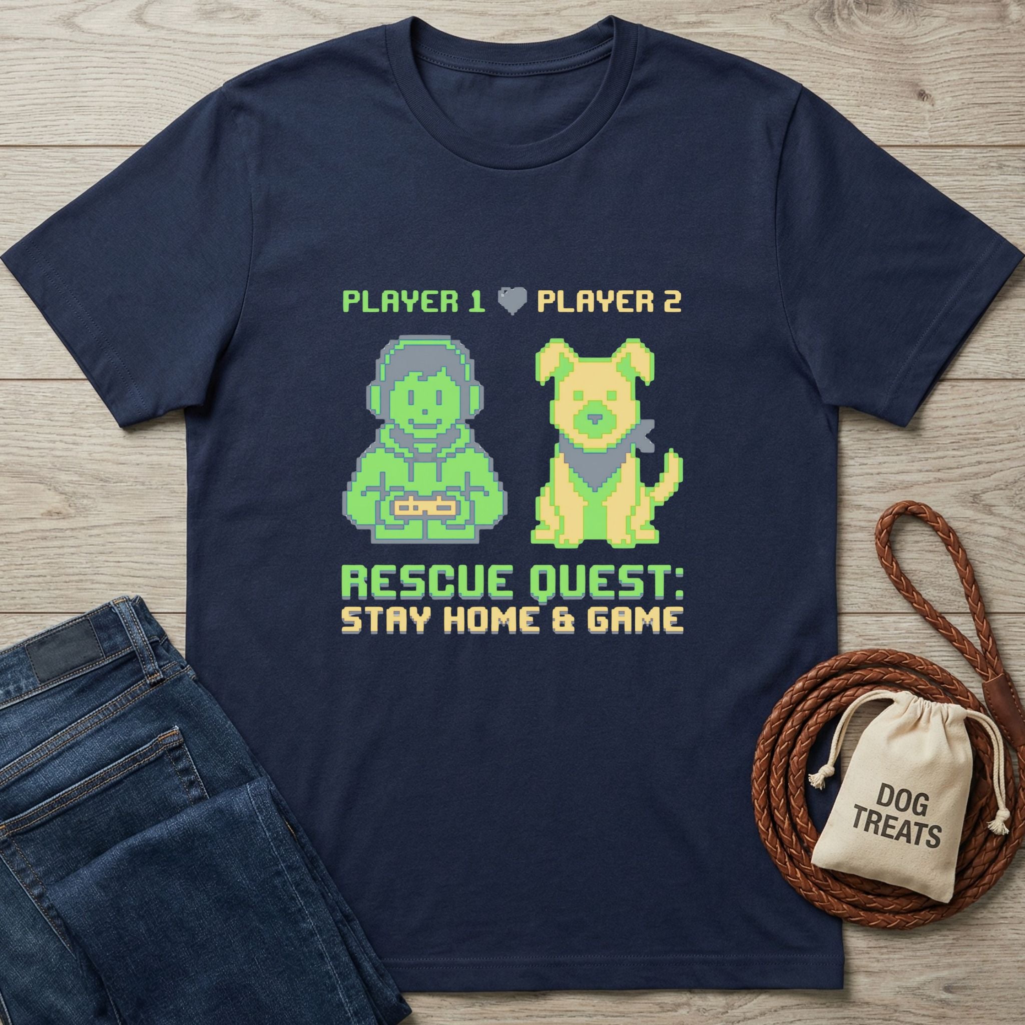 Navy blue "Rescue Quest" Gildan Softstyle® tee with pixel art of a gamer and dog, next to jeans and dog treats.