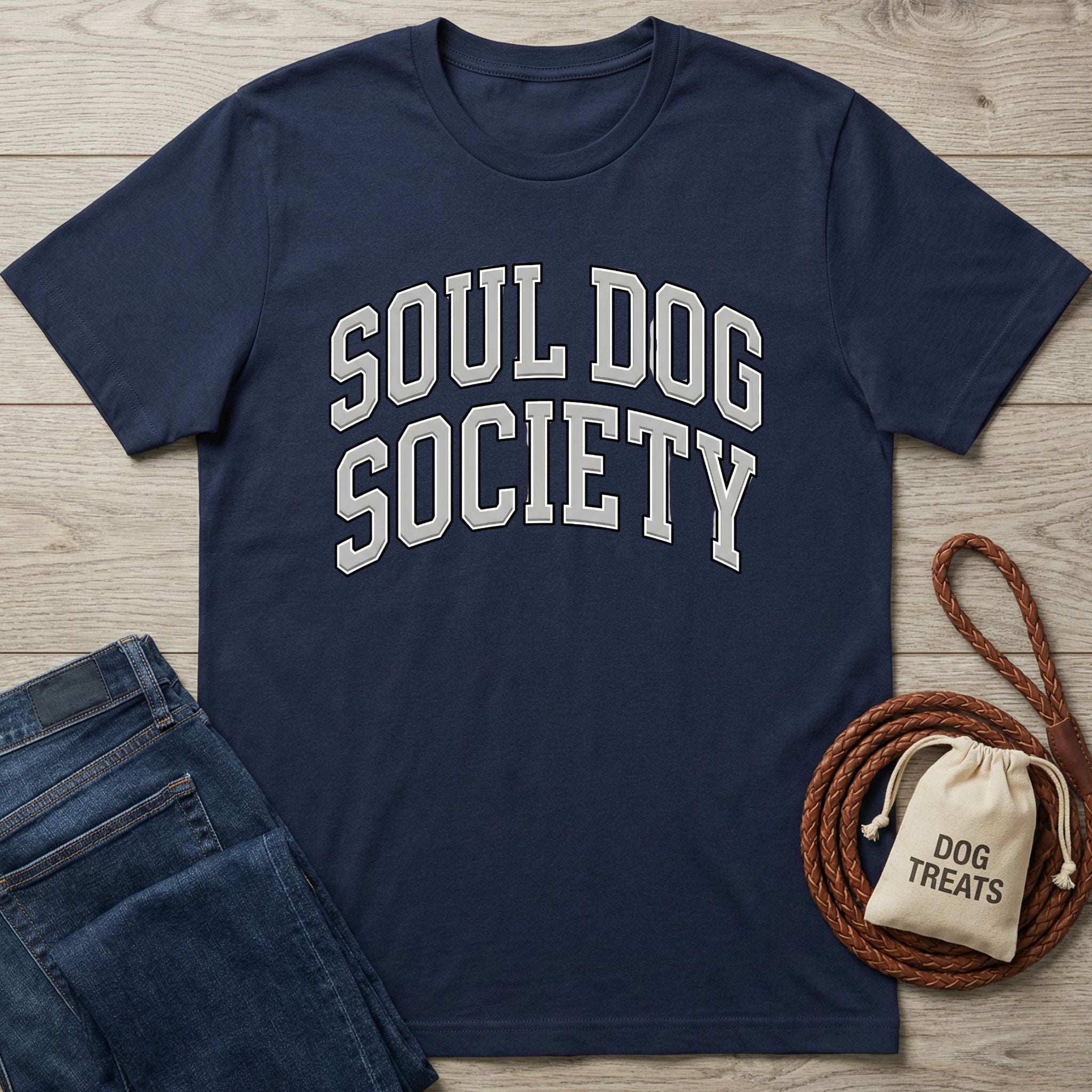 Navy blue "Soul Dog Society" t-shirt with white arched text, next to jeans and dog treats.