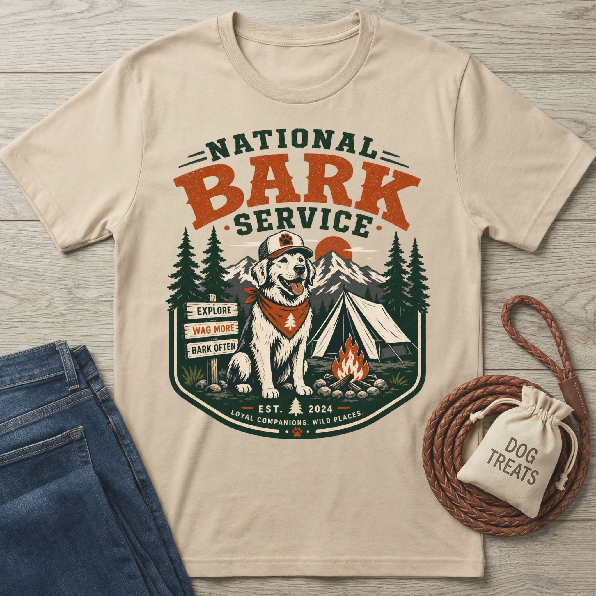 Beige crewneck t-shirt featuring a National Bark Service graphic with a dog in a hat, campfire, and mountain camping scene.
