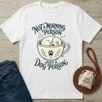 White cotton t-shirt featuring a sleeping dog in a coffee cup graphic with the text Not A Morning Person Just A Dog Person.