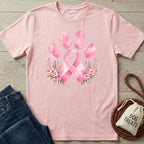 Light pink crewneck t-shirt featuring a watercolor paw print and pink ribbon design with floral accents.