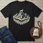 Black cotton t-shirt with a cream graphic of a dog on a mountain peak surrounded by pine trees.