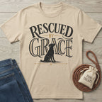 Beige crewneck t-shirt featuring a black dog illustration and Rescued By Grace typography in vintage-style black lettering.