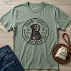 Sage green "Trust Issues Society" t-shirt with a black dog graphic, paired with jeans and a dog treat bag.