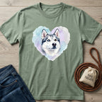Sage green Gildan Softstyle® t-shirt with a watercolor husky in a heart, next to jeans and dog treats.