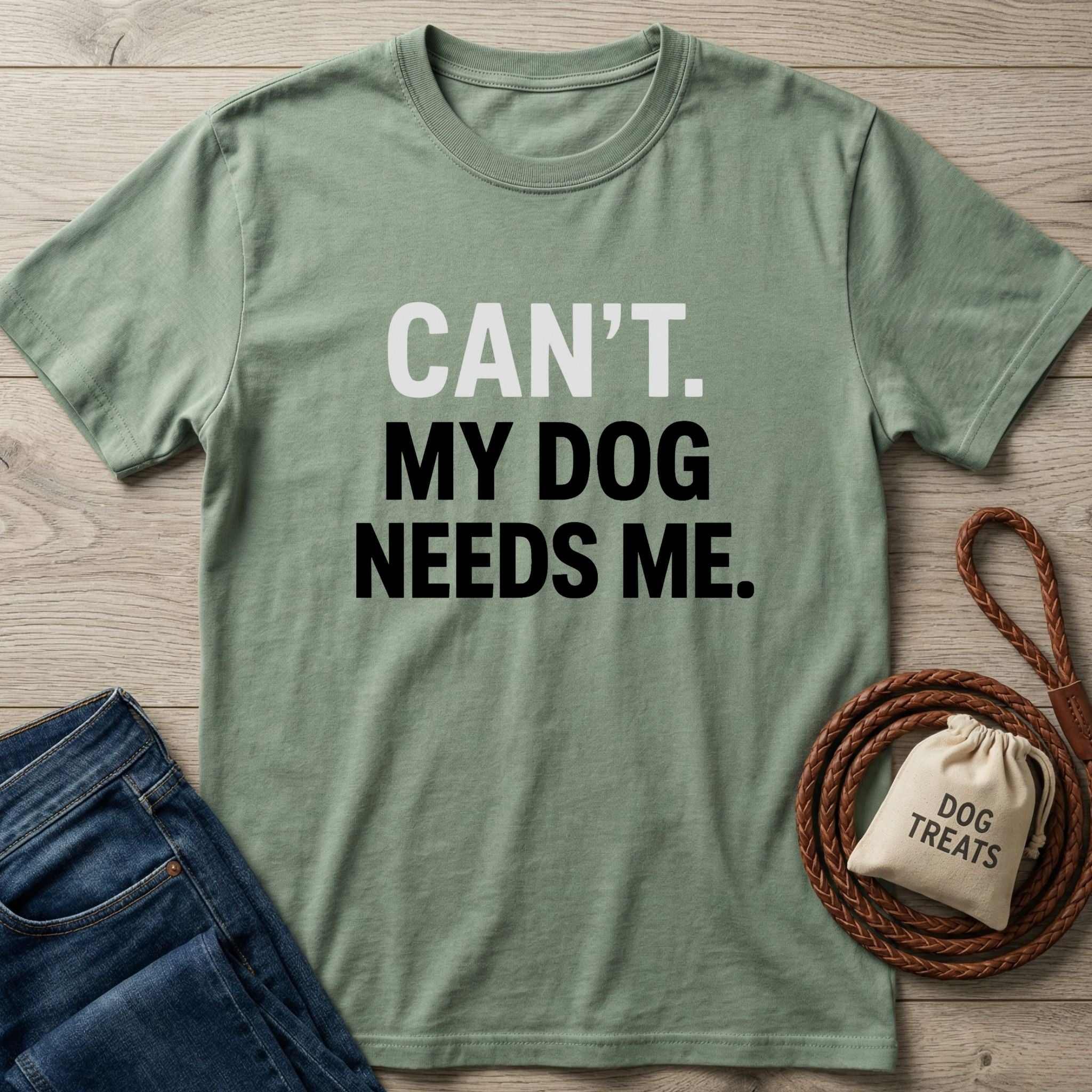 Sage green "Can't. My Dog Needs Me." t-shirt with jeans, dog leash, and treat bag.