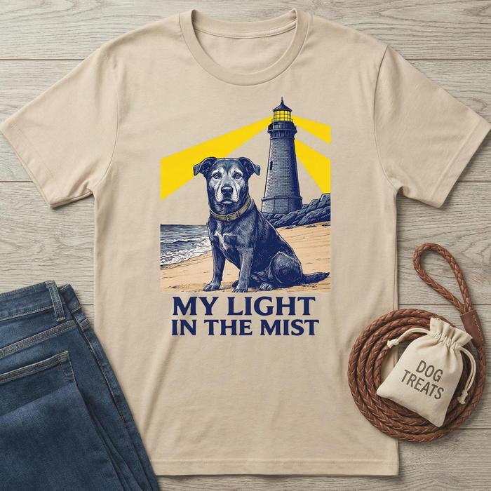 Beige cotton t-shirt with a black dog and lighthouse graphic, "My Light In The Mist" text.