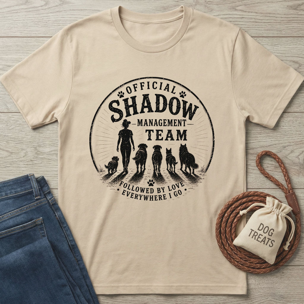 Beige cotton t-shirt with "Official Shadow Management Team" graphic featuring a person and five dogs.