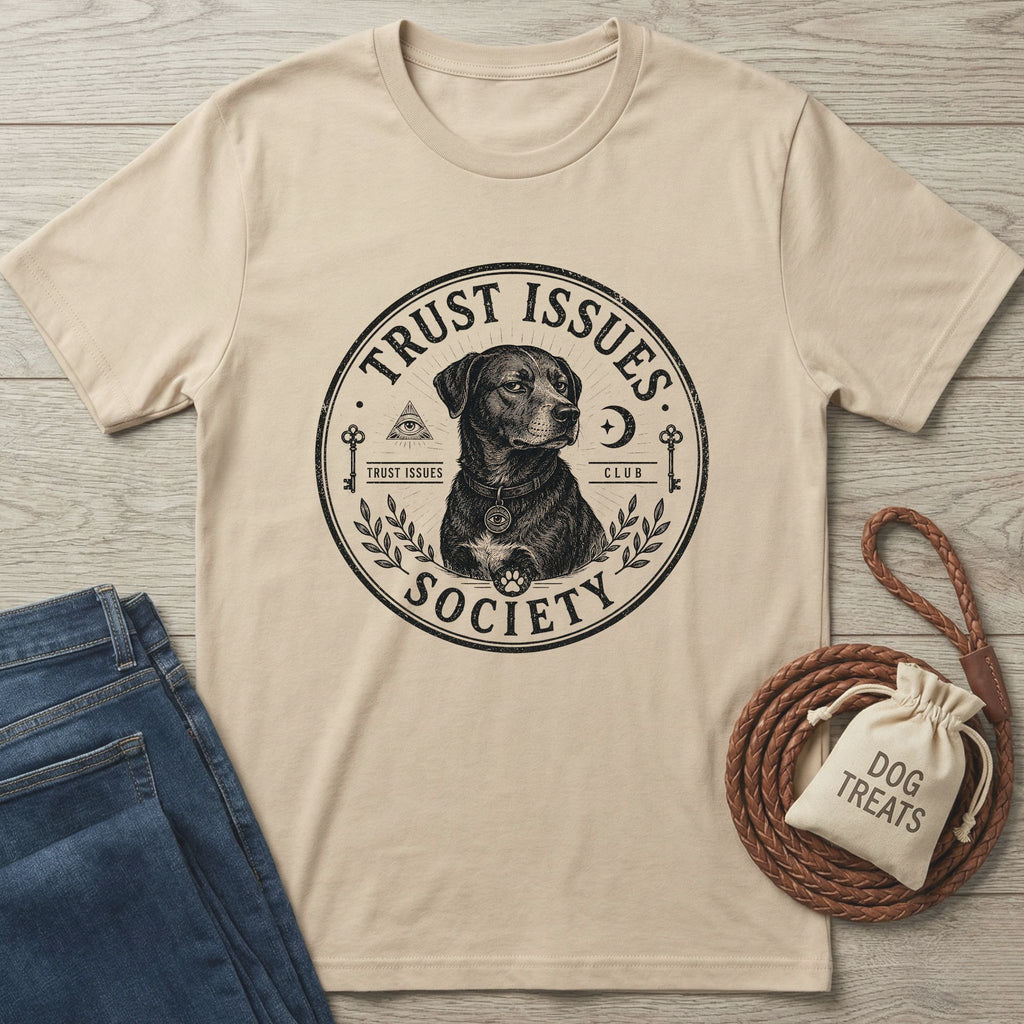 Beige cotton "Trust Issues Society" t-shirt with a black dog graphic, paired with jeans and dog treats.