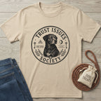Beige cotton "Trust Issues Society" t-shirt with a black dog graphic, paired with jeans and dog treats.