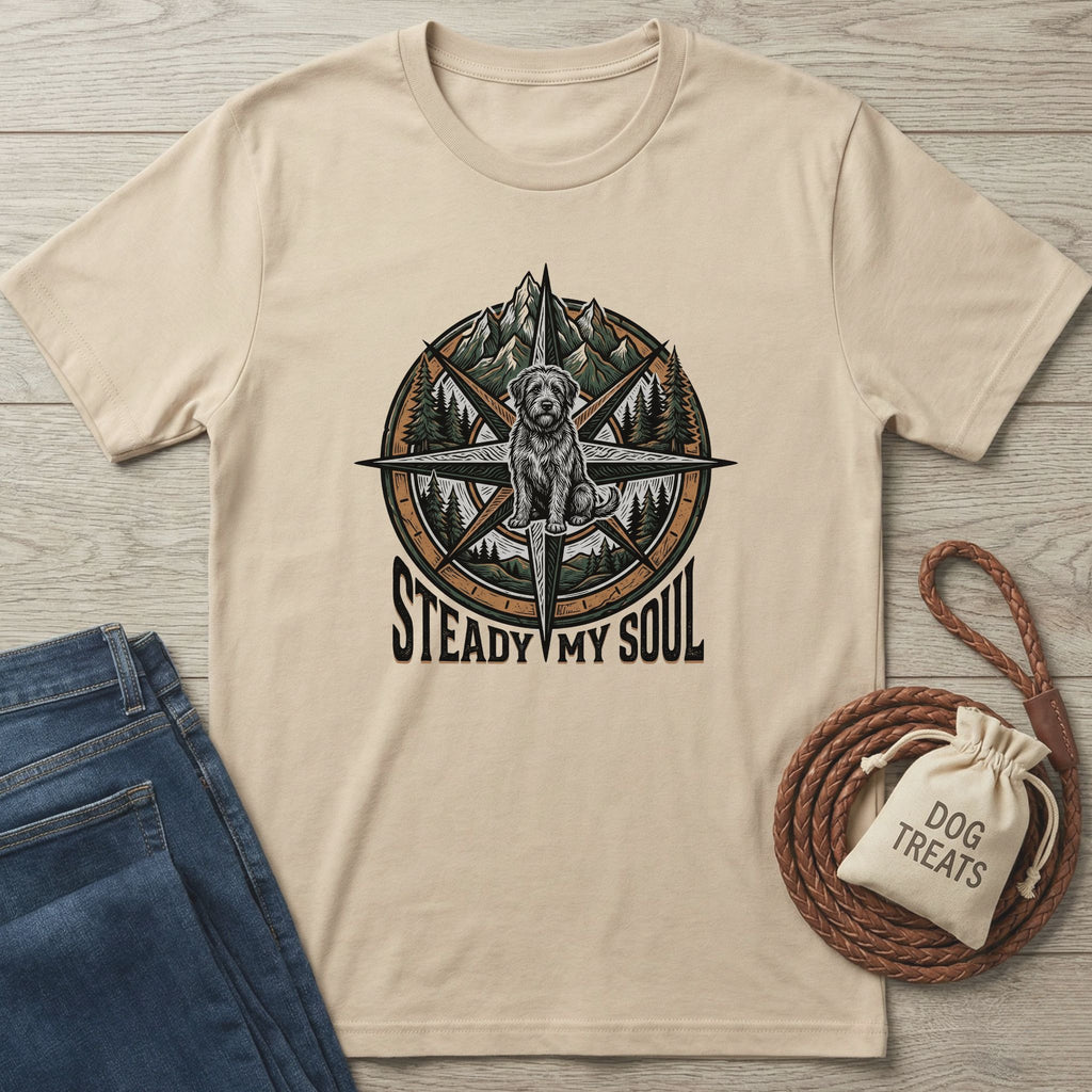 Beige Gildan Softstyle t-shirt with a compass, mountains, trees, a rescue dog, and "Steady My Soul" graphic.
