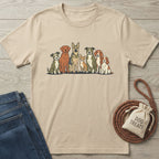 Tan Gildan Softstyle® T-shirt with a graphic of seven diverse rescue dogs, next to jeans and dog treats.