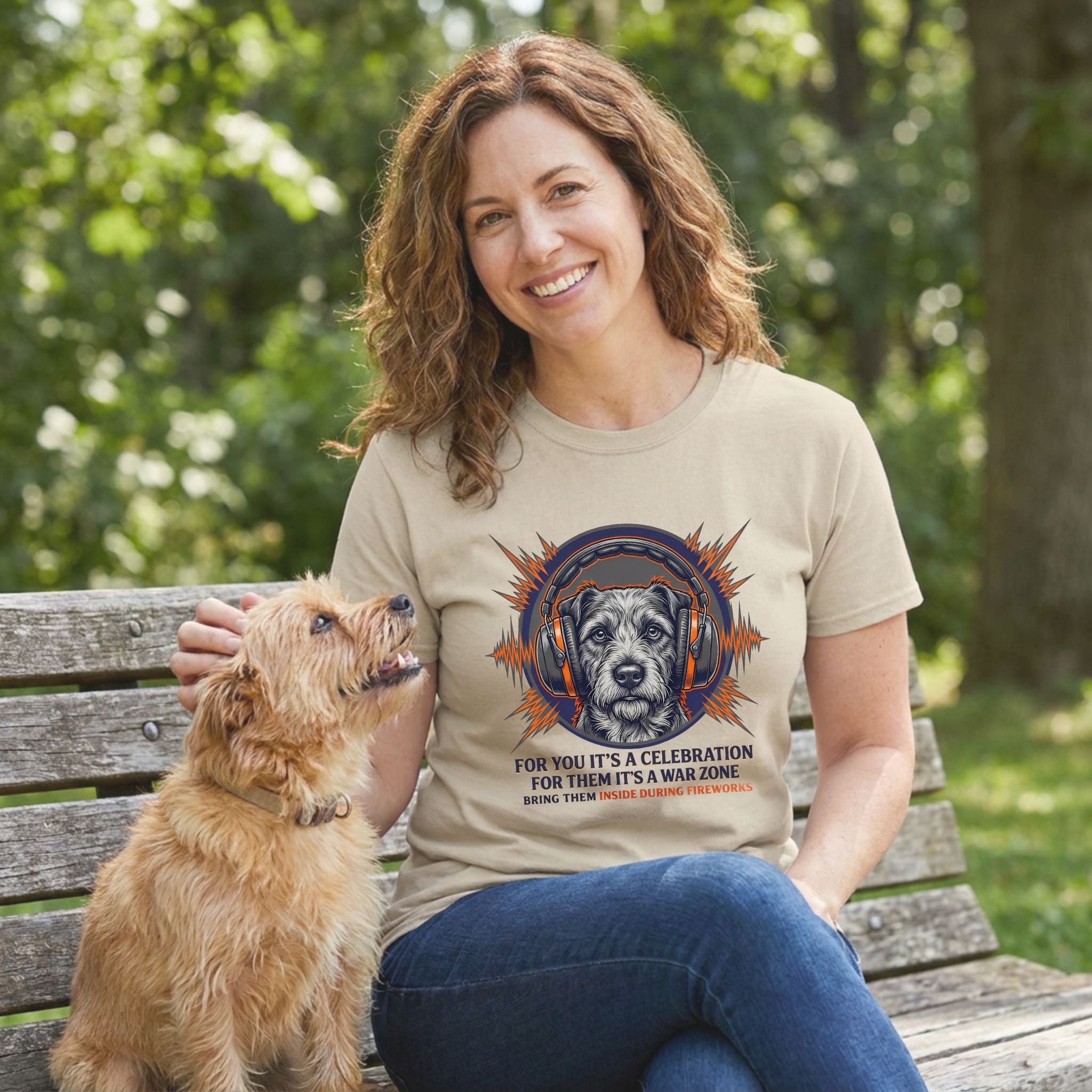 Woman in a beige "For Them It's War" t-shirt with a dog in headphones graphic, petting a small dog.
