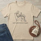 Beige Gildan Softstyle® t-shirt with "quiet nights & rescue snuggles" and line art of a person reading with a dog.