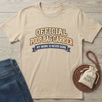 Tan Gildan Softstyle® t-shirt with "Official Poop Bag Carrier" text, next to jeans and dog treats.