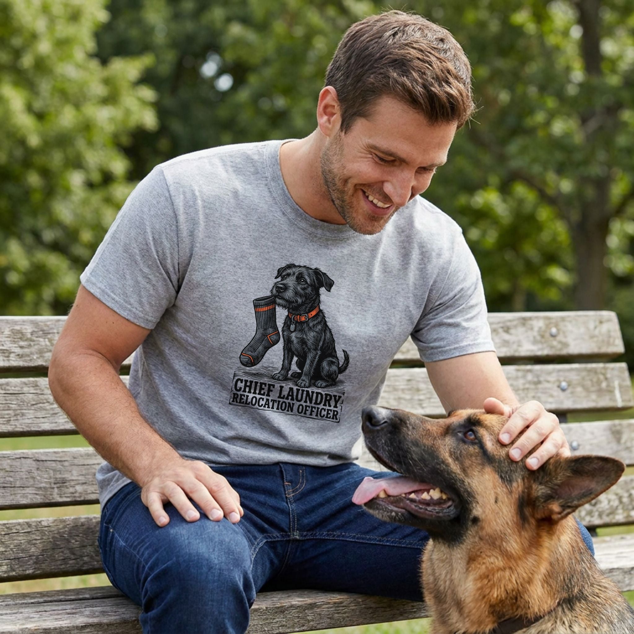 Man in a grey "Chief Laundry Relocation Officer" t-shirt with a black dog graphic, petting a German Shepherd.