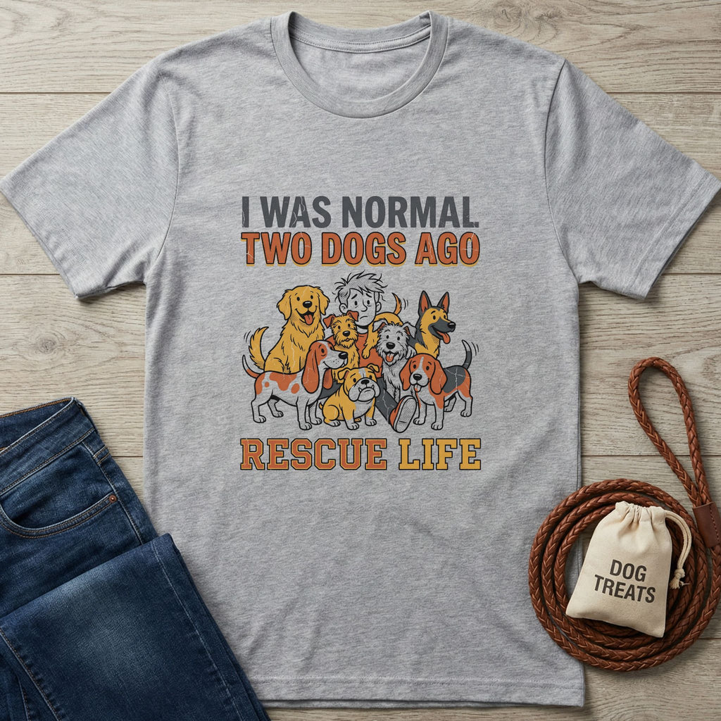 Light grey "Normal 2 Dogs Ago Rescue Life" t-shirt with cartoon dogs, next to jeans and dog treats.