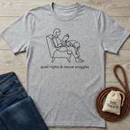 Gray heather t-shirt with black line art of a person reading with a dog, text "quiet nights & rescue snuggles.