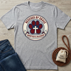 Gray cotton t-shirt with a "Rescued By Grace, Adopted & Blessed" paw print and cross design.
