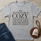 Light grey Gildan Softstyle® t-shirt with "The Architecture of Cozy" dog-themed text, paired with jeans and treats.