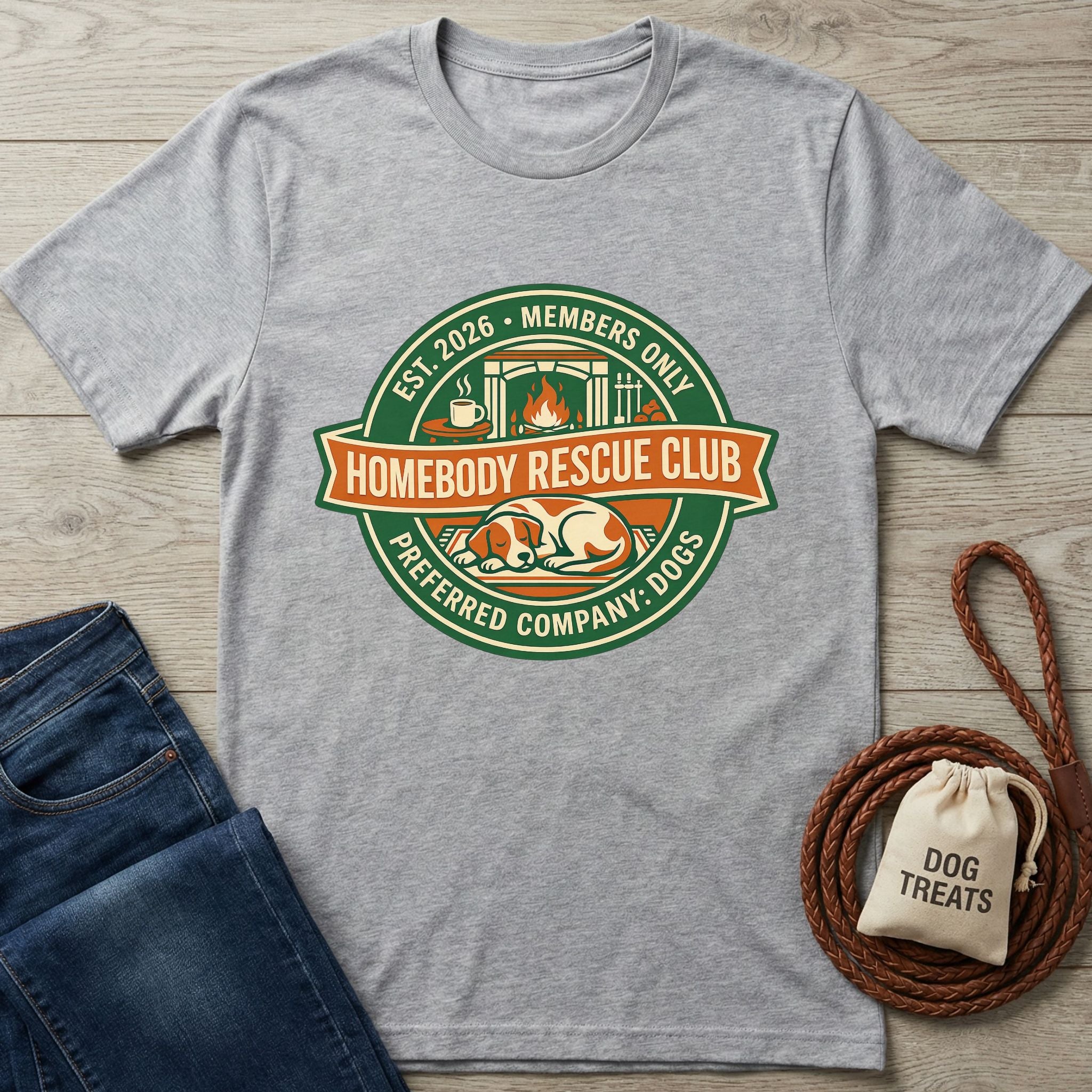 Heather grey Homebody Rescue Club t-shirt with a sleeping dog graphic, next to jeans and dog treats.