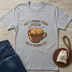 Light grey Gildan Softstyle t-shirt with a sleeping dog in a coffee cup and "Not a Morning Person, Only a Morning Dog" text.
