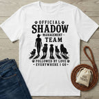 White cotton t-shirt with "Official Shadow Management Team" graphic featuring a person and five dogs.