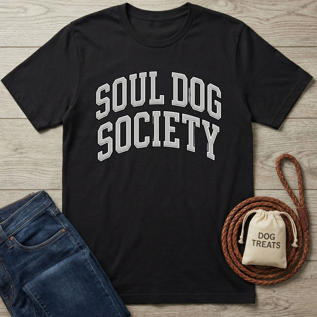 Black cotton t-shirt with "SOUL DOG SOCIETY" in arched silver text, beside blue jeans and dog accessories.