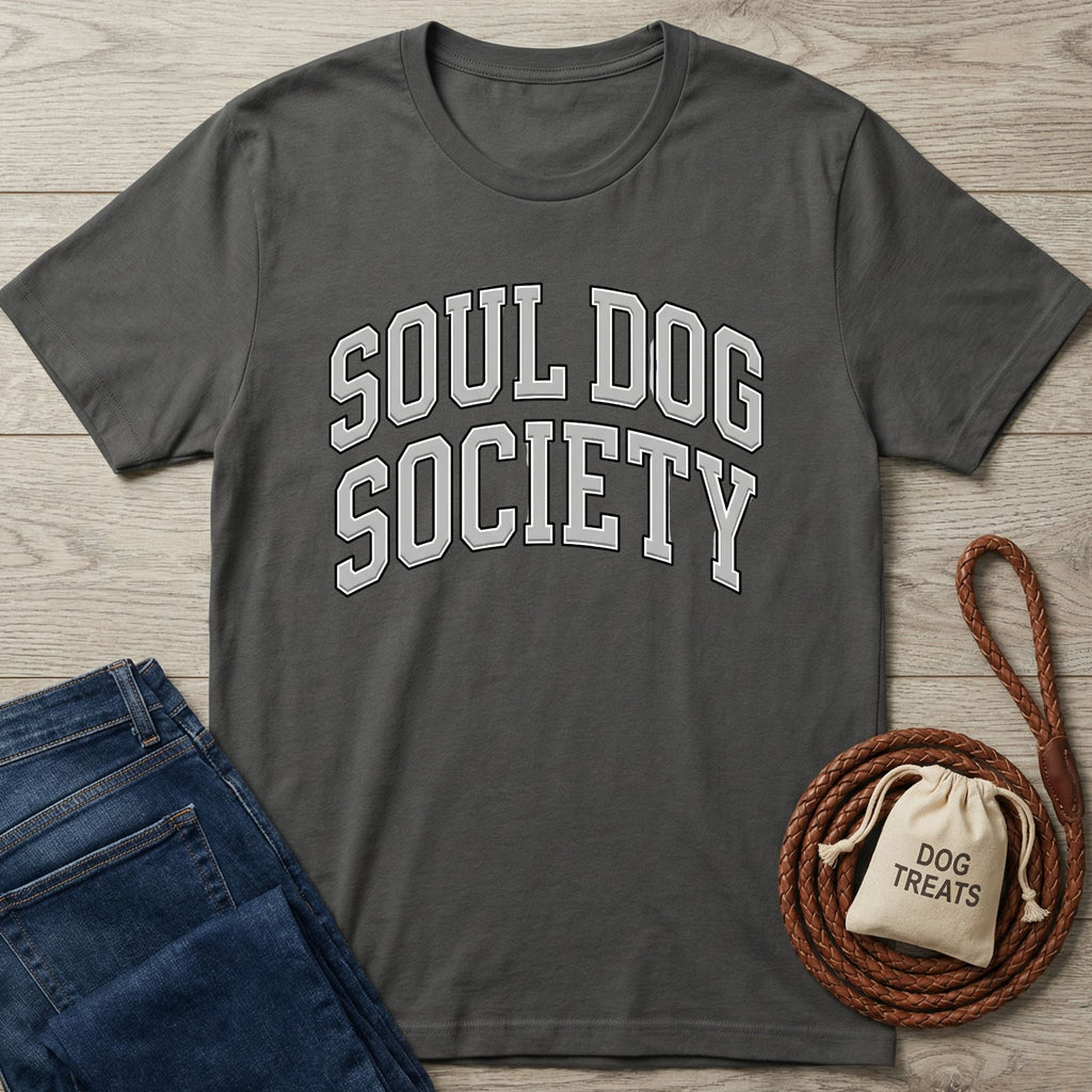 Dark gray "Soul Dog Society" t-shirt with white arched text, next to blue jeans and dog treats.