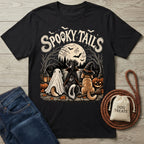 Black cotton t-shirt featuring three dogs in Halloween costumes sitting by a lake under a full moon with Spooky Tails text.