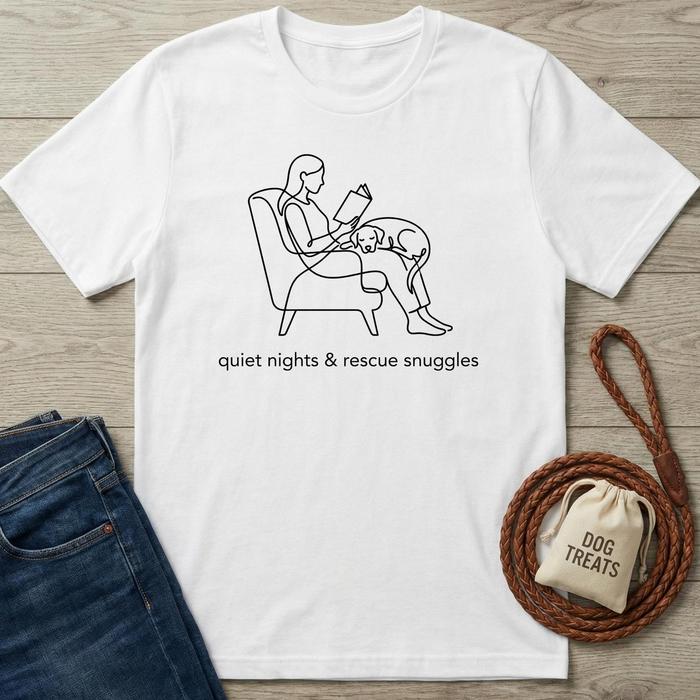 White cotton t-shirt with "quiet nights & rescue snuggles" text and line art of a person reading with a dog.