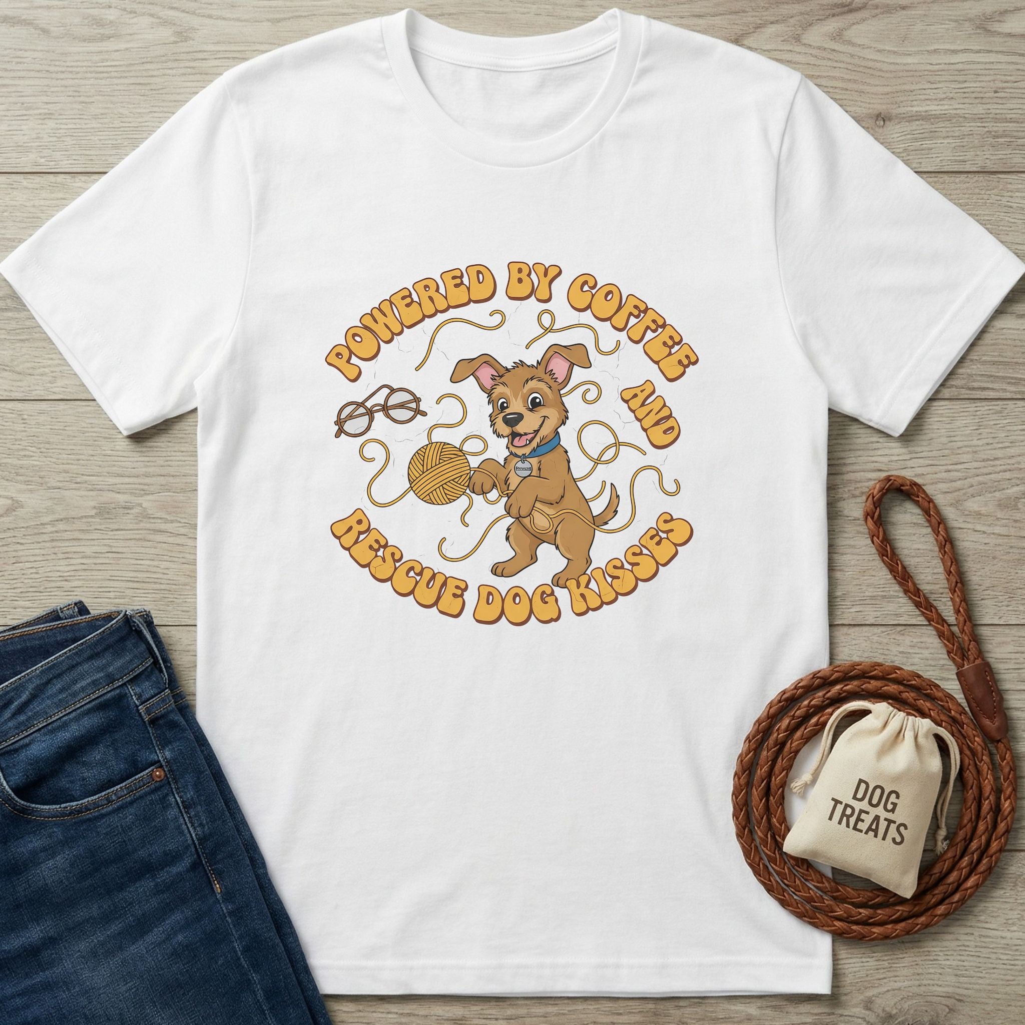 White Gildan Softstyle® t-shirt with "Powered by Coffee & Rescue Dog Kisses" graphic, jeans, and dog leash.