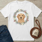 White t-shirt with a golden retriever design, jeans, dog leash, and treat bag on a wooden surface.