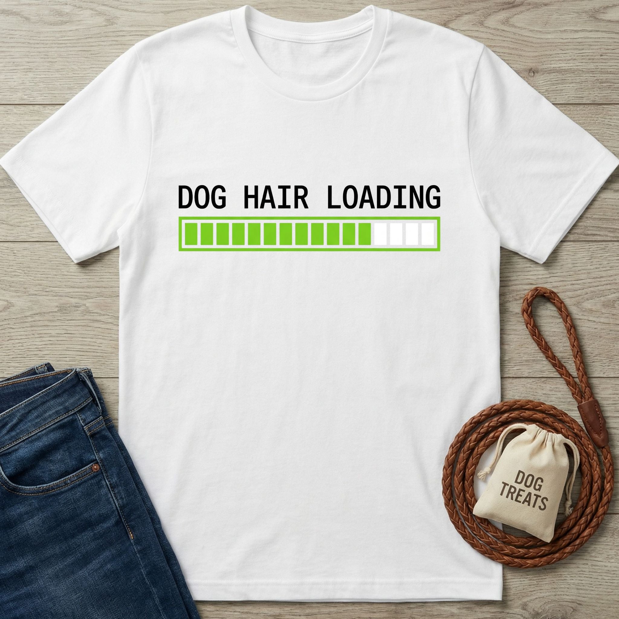 White cotton t-shirt with "DOG HAIR LOADING" text and a green progress bar, next to blue jeans and a dog leash.