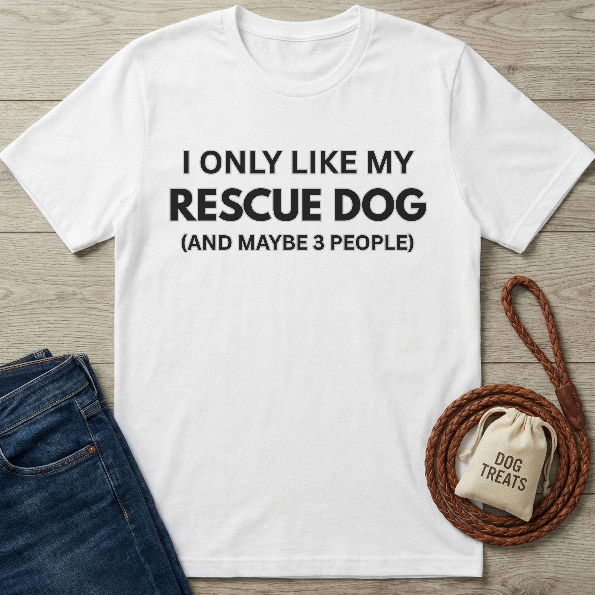 White cotton t-shirt with "I ONLY LIKE MY RESCUE DOG (AND MAYBE 3 PEOPLE)" text, next to jeans and dog leash.
