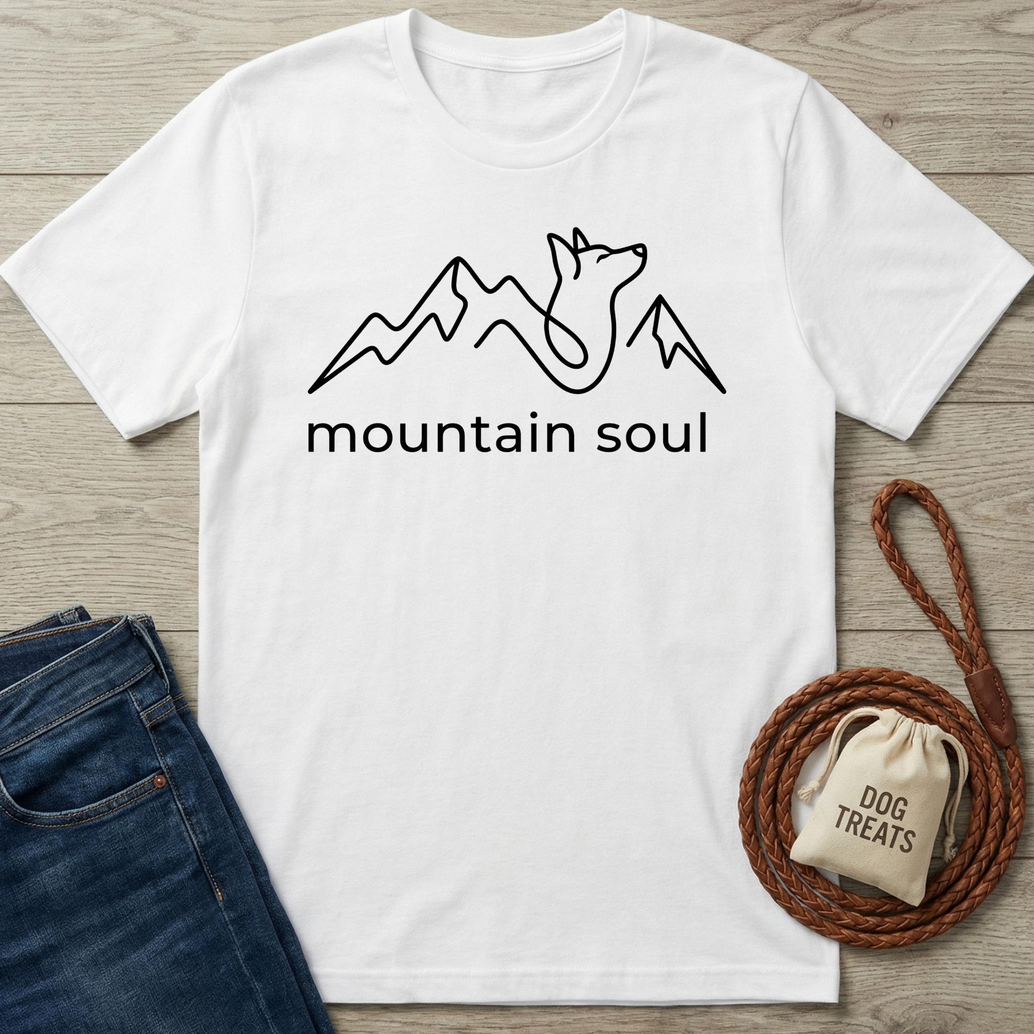White cotton t-shirt with a black line art design of mountains and a howling wolf, "mountain soul" text.