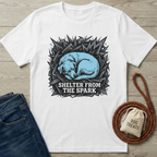 White cotton t-shirt with a blue sleeping dog design, "Shelter From The Spark" text, dark jeans, and dog accessories.