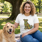 Woman in white "Love In Color" t-shirt with vibrant dog design, petting a golden retriever in a park.