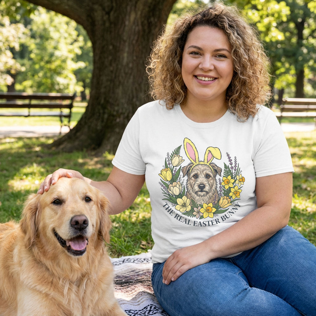 Woman in white "The Real Easter Bunny" t-shirt with a dog in a floral wreath, petting a golden retriever.