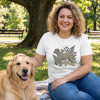 Woman in a white "Rescue Specimen" t-shirt with a dog graphic, petting a golden retriever in a park.