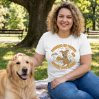 Woman in a white "Powered by Coffee & Rescue Dog Kisses" t-shirt petting a golden retriever in a park.
