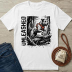White "Unleased" T-shirt with a jumping dog in an orange harness, next to jeans and dog treats.