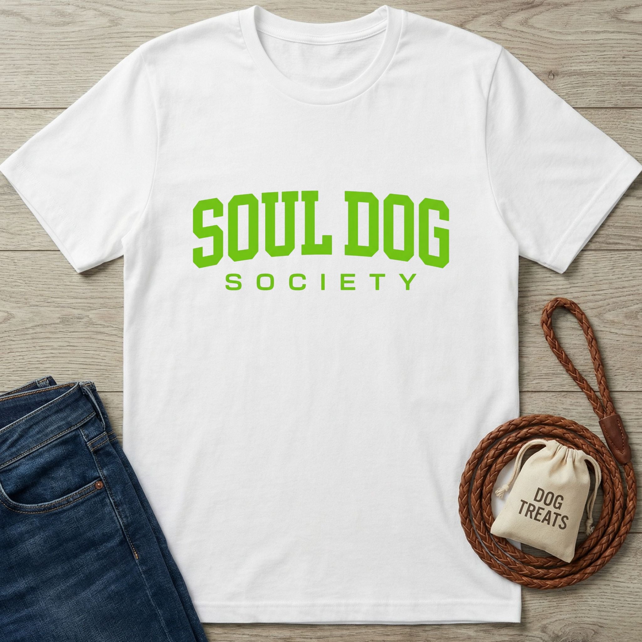 White Gildan Softstyle t-shirt with "SOUL DOG SOCIETY" in bright green text, next to jeans and a dog leash.