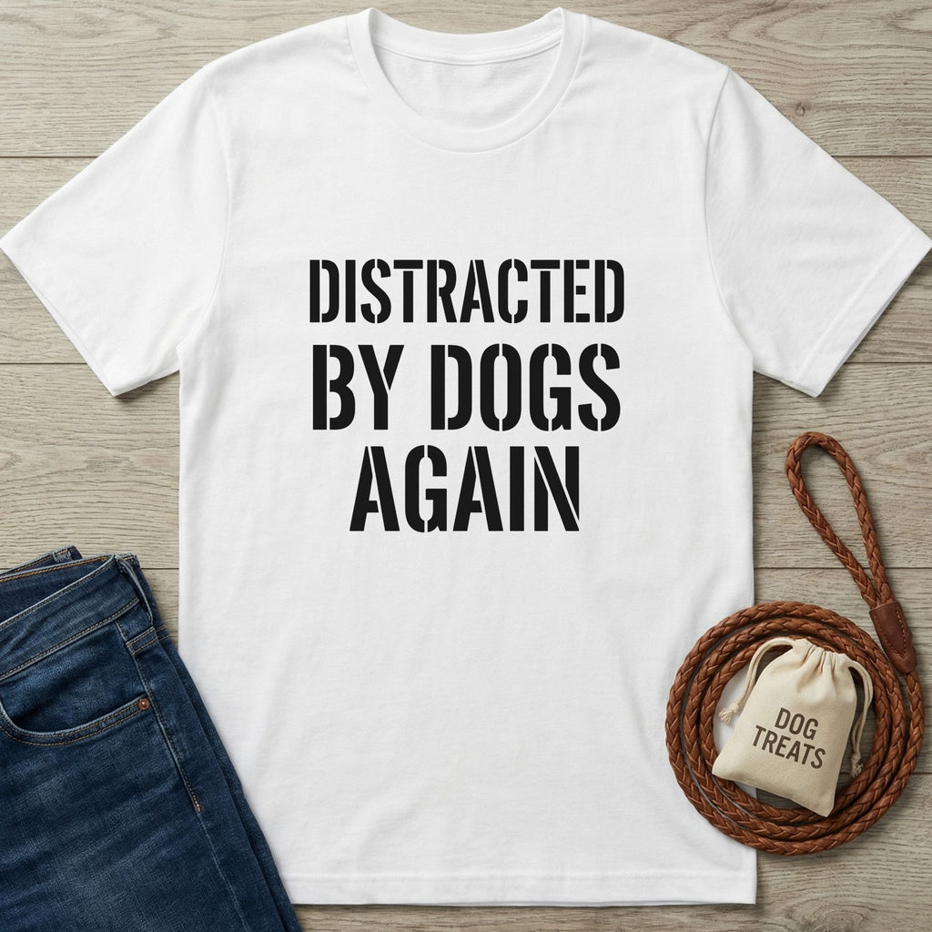 White Gildan Softstyle® t-shirt with "DISTRACTED BY DOGS AGAIN" in black text, next to jeans, a leash, and dog treats.