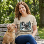 Woman wearing a beige crewneck t-shirt with a husky and pine tree graphic and the text Winter Wanderer.